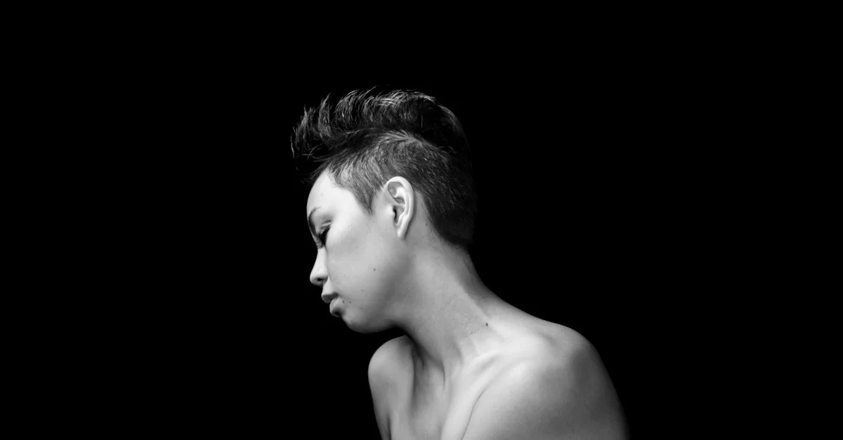 Portrait artistique en noir et blanc de profil d'une femme aux cheveux courts.