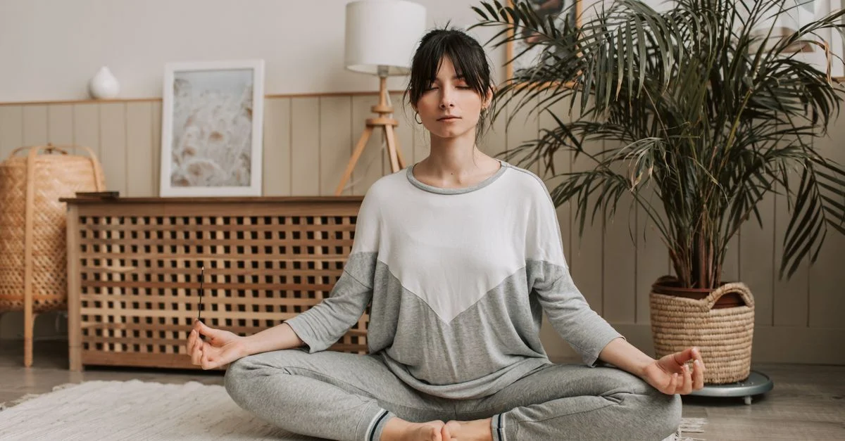 Femme méditant en position du lotus à l'intérieur, embrassant la détente et la tranquillité.